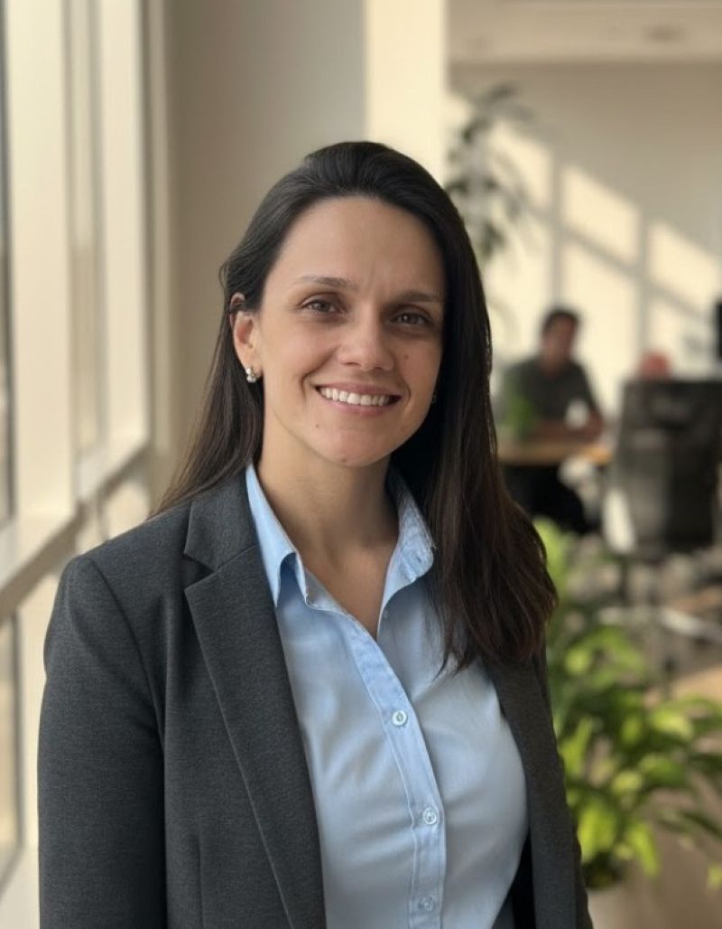 Michele Gennaro, psicóloga CRP 06/159123, sorrindo em ambiente profissional